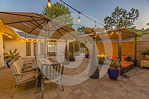 Outdoor dining and seating area on the cozy stone patio of a home