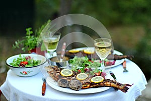 Outdoor dinner with grilled fish salad and coal roasted potatoes