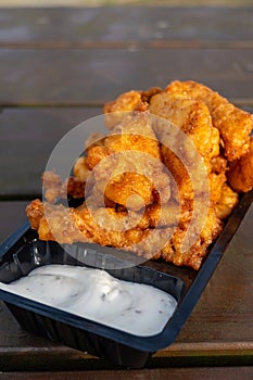 Outdoor eating of diep-fried cod fish pieces served with remoulade sauce, Dutch street food