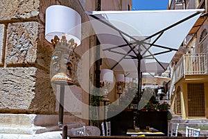 Outdoor eating of a restaurant or cafe in Taormina, Sicily. Decorative lamps and set tables for dining