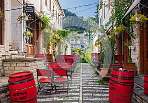 Outdoor empty coffee and restaurant terrace with colorful tables and chairs. Old fashioned cafe terrace in Berat