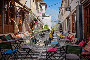 Outdoor empty coffee and restaurant terrace with colorful tables and chairs. Old fashioned cafe terrace in Berat