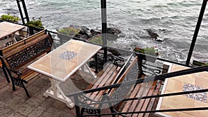 Outdoor empty restaurant table with metallic chairs on the terrace of a restaurant by the sea