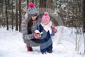 Outdoor family activities for happy winter holidays. Happy father and mother playing with little baby toddler girl