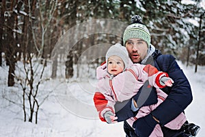 Outdoor family activities for happy winter holidays. Happy father playing with little baby toddler girl daughter in