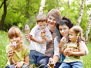 Outdoor family with kids on green grass.