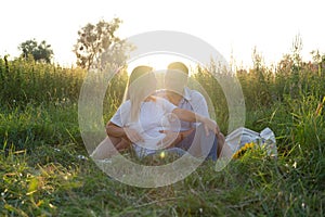 Outdoor family portrait: beautiful young pregnant female and her husband, hands on belly, anticipate child, enjoy