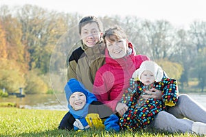 Outdoor family portrait of parents with two siblings in park