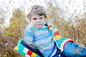 Outdoor fashion portrait of adorable little kid boy wearing colorful clothes