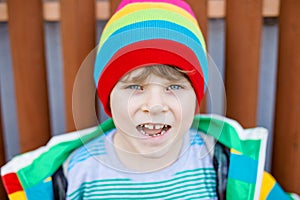 Outdoor fashion portrait of adorable little kid boy wearing colorful clothes