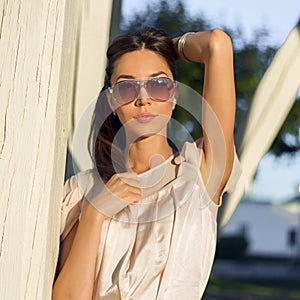 Outdoor fashion portrait glamor sensual young stylish woman in glasses, wearing a delicate summer dress outfit brunette