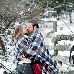 Outdoor fashion portrait of young sensual couple in cold winter weather. love and kiss