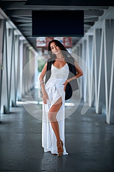 Outdoor fashion portrait of young woman posing in the corridor