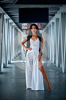 Outdoor fashion portrait of young woman posing in the corridor