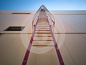 Outdoor fire escape ladder on industrial building wall
