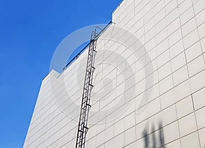 Outdoor fire escape on the wall of an office or industrial building. Bottom-up view. Fire escape on the facade of the