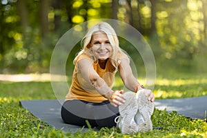 Outdoor Fitness. Portrait Of Beautiful Senior Woman Stretching Leg Muscles