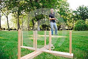 Outdoor games - guy playing ring toss in a park.