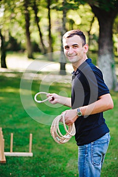 Outdoor games - guy playing ring toss in a park.