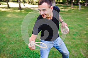 Outdoor games - guy playing ring toss in a park.