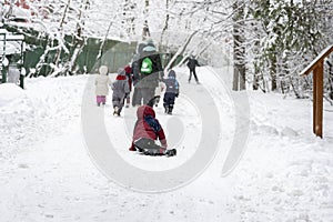 Outdoor games, winter leisure, several of unrecognizable little kids with teachers of kindergarten, walk holding hands