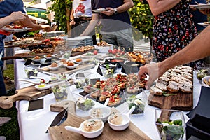 Outdoor garden party with buffet table full of canapes.