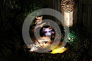 Outdoor garden with water feature fishpond at nigh