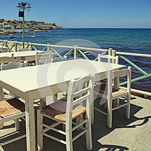 Outdoor greek cafe terrace overlooking the sea, Crete, Greece