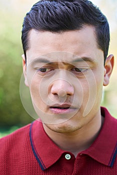 Outdoor Head And Shoulder Portrait Of Worried Young Man