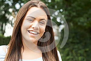 Outdoor Head And Shoulders Portrait Of Smiling Teenage Girl