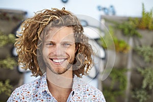 Outdoor Head And Shoulders Portrait Of Smiling Young Man