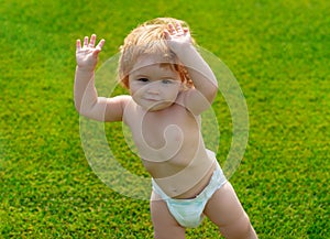 Outdoor kids in diaper activities. Family summer holidays with children. Children in diapers playing in the green grass