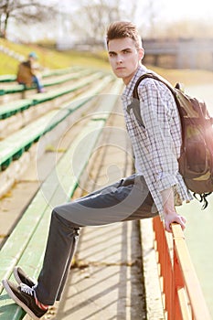 Outdoor lifestyle portrait of handsome guy with backpack