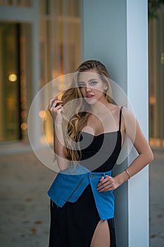 Outdoor lifestyle portrait of pretty young fashion model in urban background. Outdoor elegant fashionable woman walking