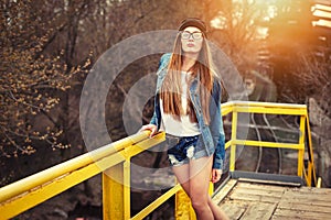 Outdoor lifestyle portrait of pretty young girl, wearing bright hipster swag dress, urban background