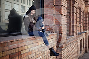 Outdoor lifestyle portrait of pretty young girl, wearing hipster swag grunge style on urban background. Wearing hat and jeans