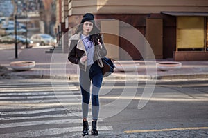 Outdoor lifestyle portrait of pretty young girl, wearing in hipster swag grunge style on urban background. Wearing hat and jeans