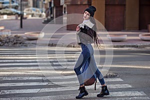 Outdoor lifestyle portrait of pretty young girl, wearing hipster swag grunge style on urban background. Wearing hat and jeans with