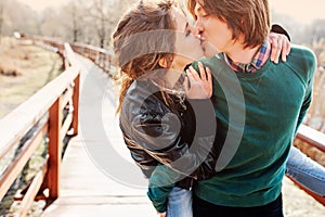 Outdoor lifestyle portrait of young happy couple kissing