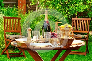 Outdoor Lunch Table With Bottle Of Wine On The Backyard