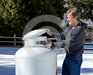 Outdoor man in winter prepares to open propane tank valves