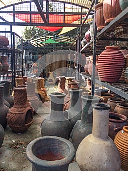 Outdoor market with metal racks of Mexican pottery and chimeneas photo