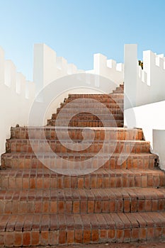 Outdoor Masonry Stairway with White Crenellated Walls at a Luxur photo