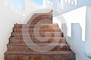 Outdoor Masonry Stairway with White Crenellated Walls at a Luxur photo