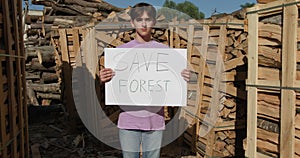 Outdoor of men activist with Save the forest ecology poster. In background chopped trees