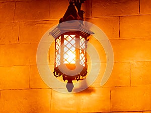 Outdoor old vintage lamp light glowing in the dark. Beautiful dusty lantern hang in front of house in the night