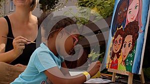 Outdoor painting art class for kids. Children paint with paints during open air.