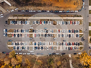Outdoor parking lot or car park with rows of autos in urban landscape, aerial or top view