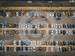 Outdoor parking lot or car park with rows of autos in urban landscape, aerial or top view