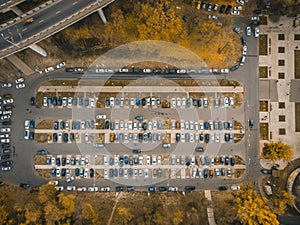 Outdoor parking lot or car park with rows of autos in urban landscape, aerial or top view